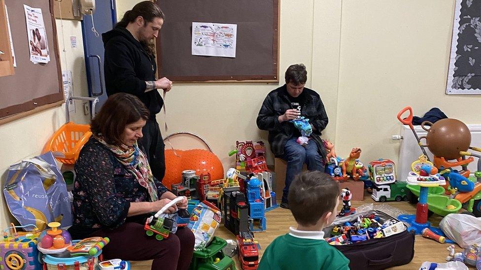 Volunteers checking batteries and toy quality