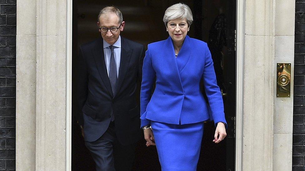 Theresa May heads out of Downing Street on her way to see the Queen