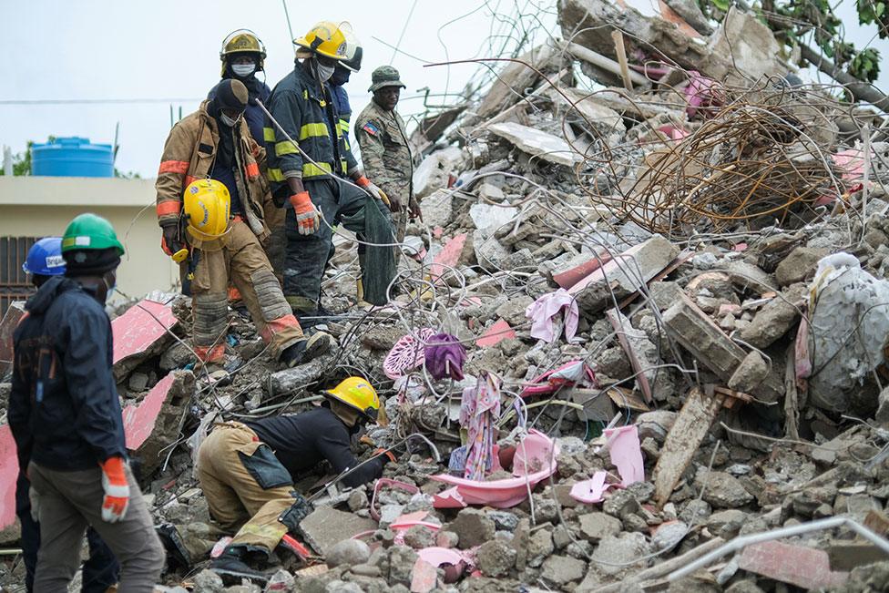 Haitian firefighters search for survivors under the rubble of a destroyed building in Les Cayes, Haiti, on 17 August 2021