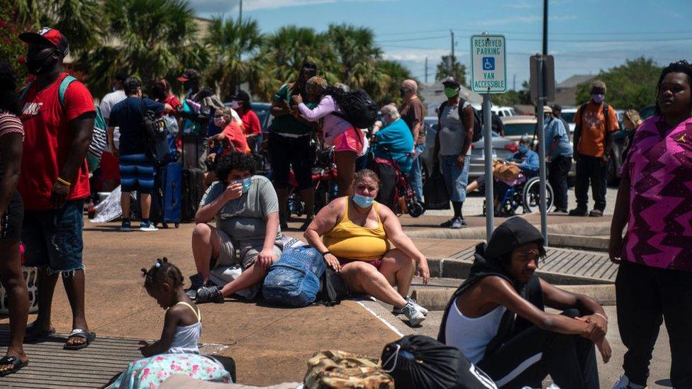 Brayan Nelson Ponce, 15, and Frances Nelson, 46, wait to board a bus as residents evacuate ahead of Hurricane Laura at the Island Community Center on August 25, 2020 in Galveston, Texas