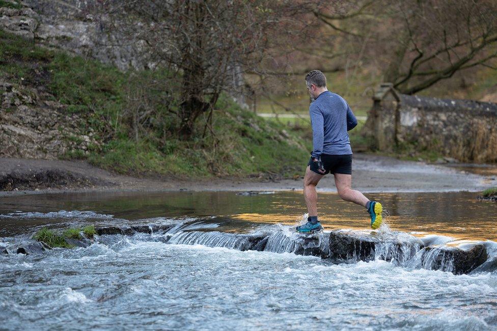 A runner leaps over the dislodged stones on 24 November 2023