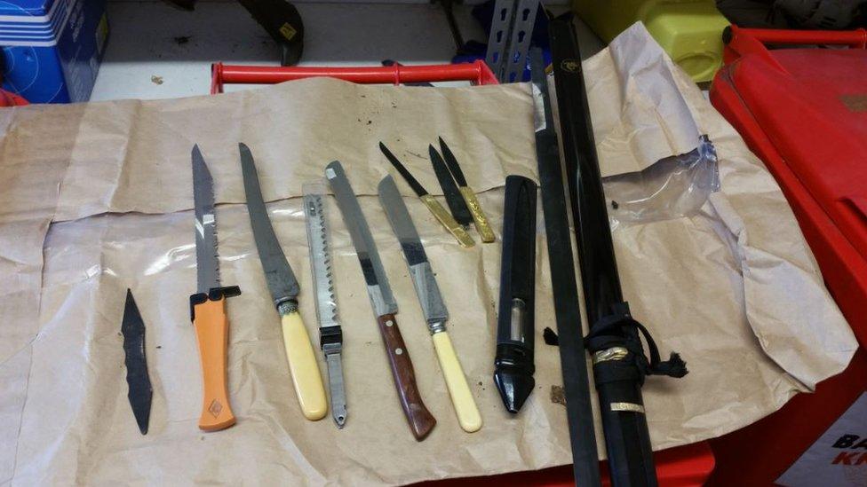 Several knives and weapons laid out on a table