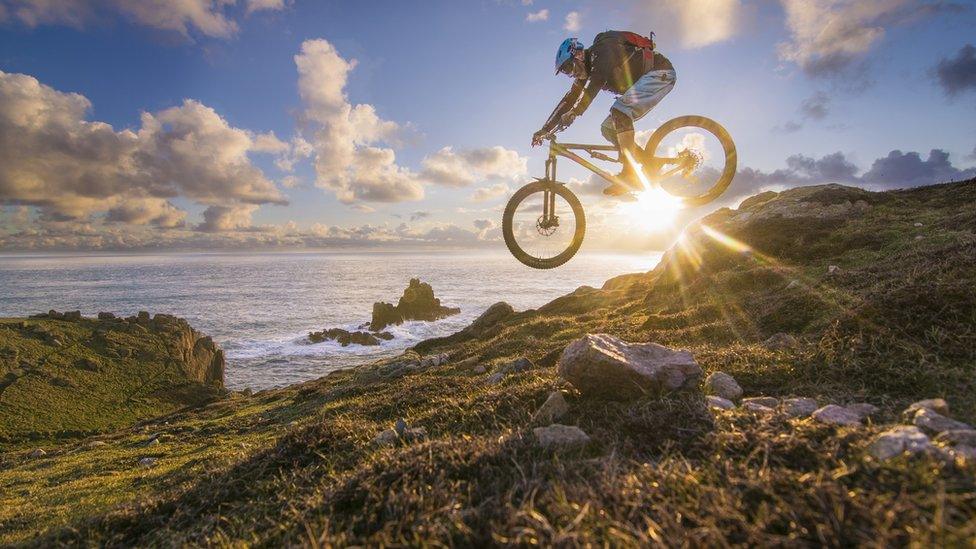 A rider on a bike closer to the sea