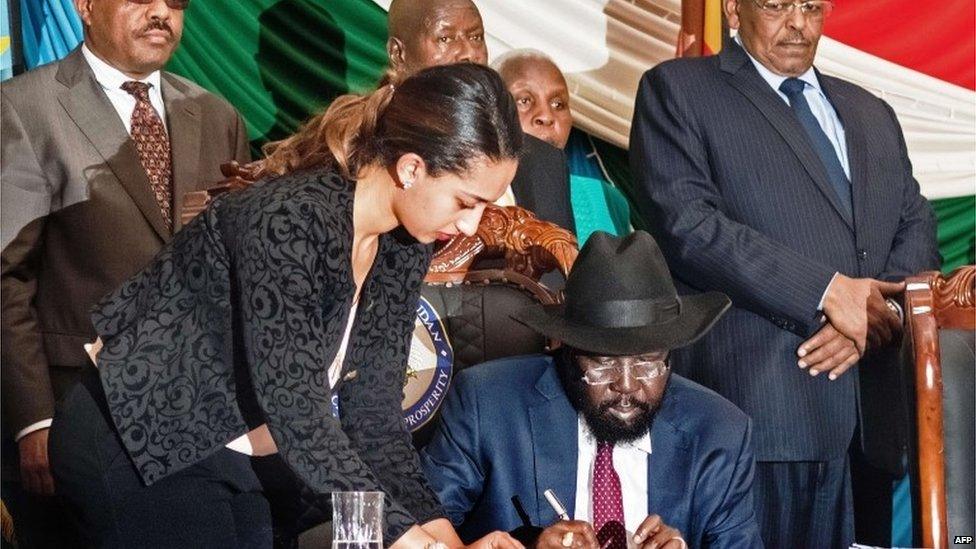 Salva Kiir signs the deal, as regional leaders look on