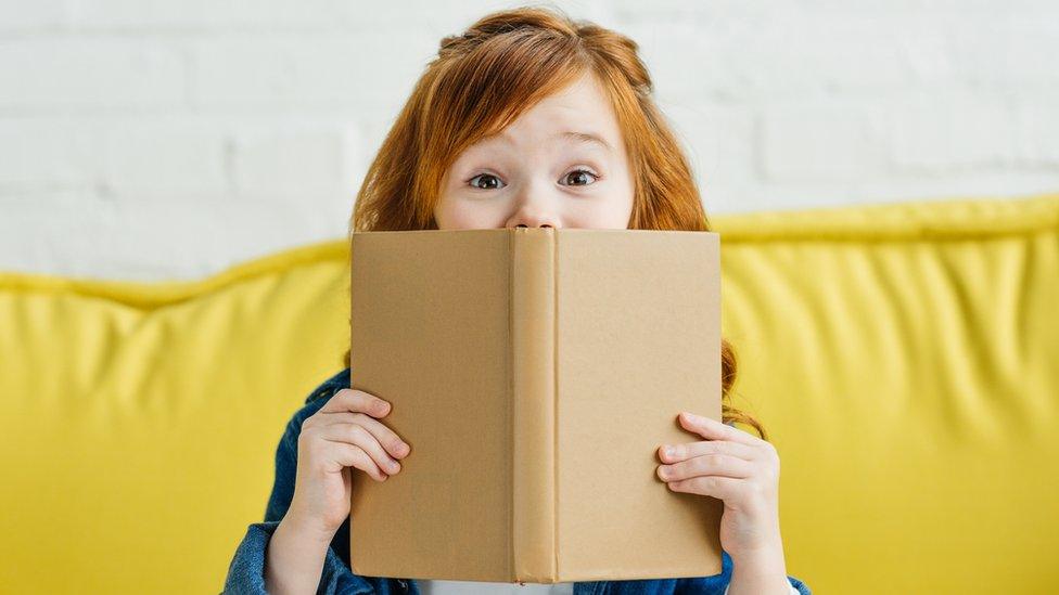 girl-hiding-behind-book.