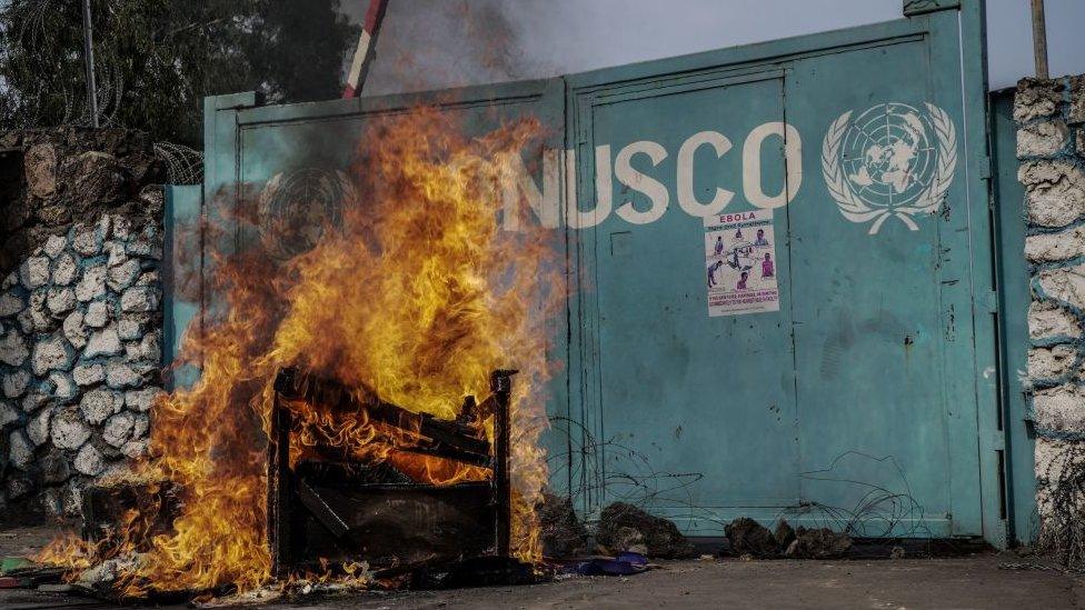 A picture taken in Goma, on July 25, 2022 shows fire set by protesters burning in front of United Nations Mission for the Stabilisation of Congo (MONUSCO) Headquarters