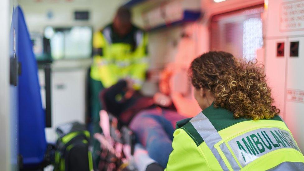 Paramedics treat a patient in an ambulance