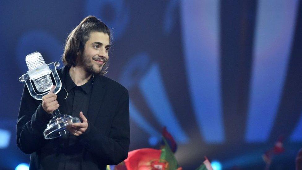 Portuguese singer Salvador Sobral holding the glass microphone trophy after winning the 2017 Eurovision Contest