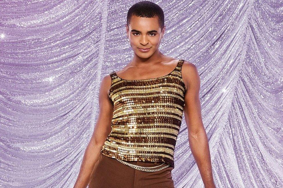 Layton Williams in a sparkly top and brown trousers