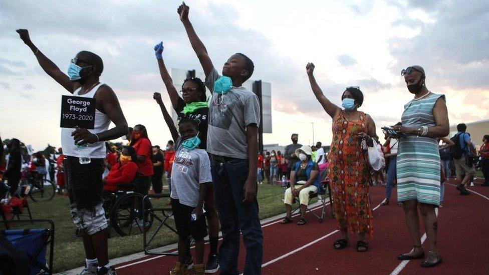Local-families-raise-their-fists-to-show-support.
