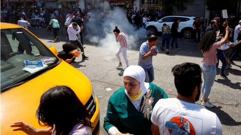 Protesters in Ramallah disperse amid tear gas during demonstration over the death of Nizar Banat (24/06/21)