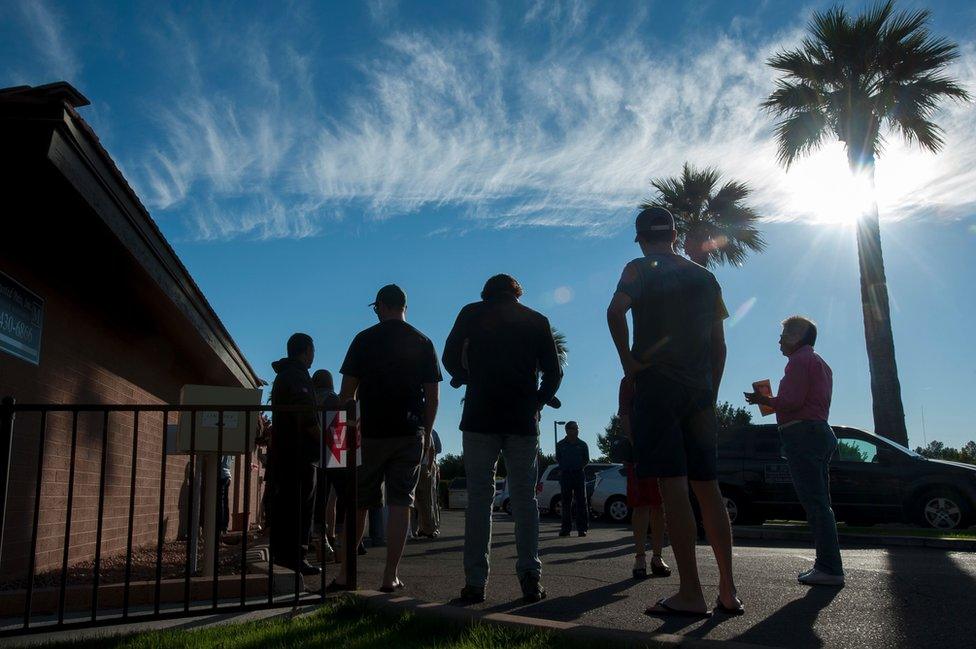 Voters wait in line in front of a polling station to cast their ballots in the US presidential election in Scottsdale, Arizona