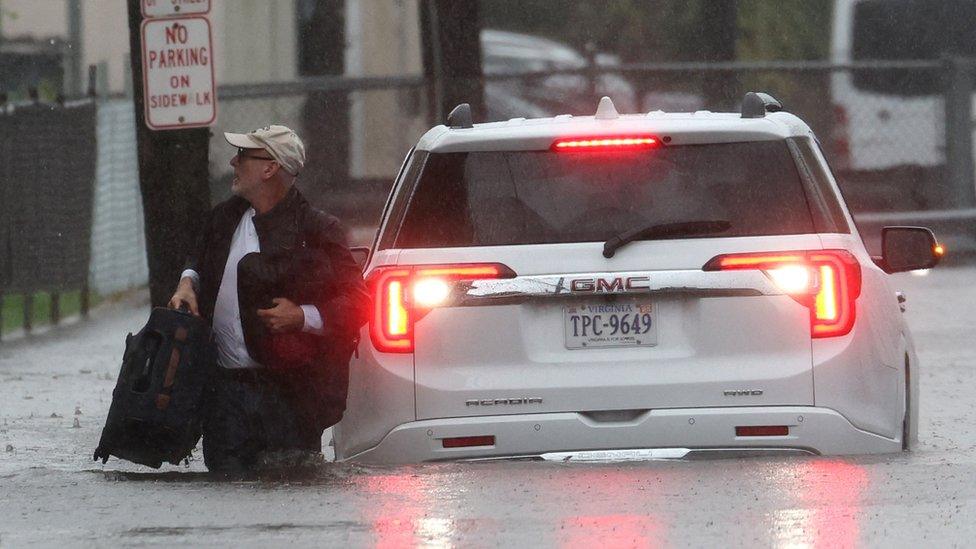 A man walks through flood waters in New York