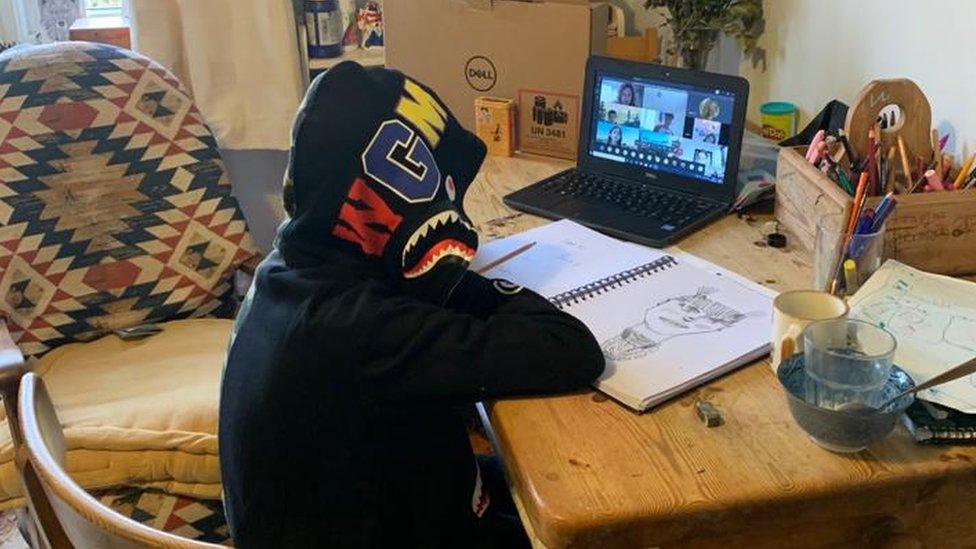 Vicky Price's son sitting at a table doing his homework