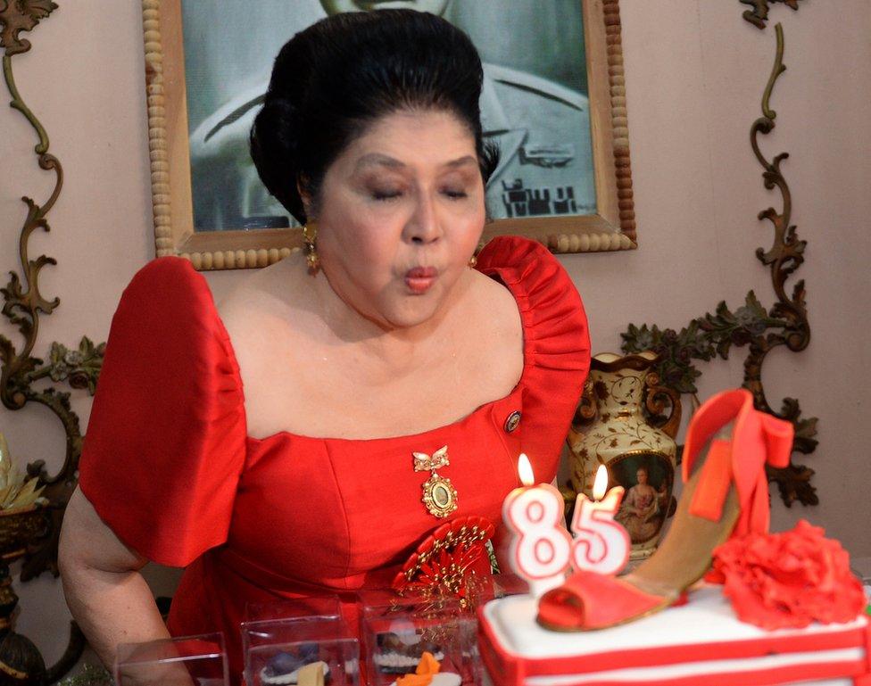 Former Philippines first lady and now congresswoman Imelda Marcos blows out the candles on a cake designed with a shoe during her 85th birthday celebrations