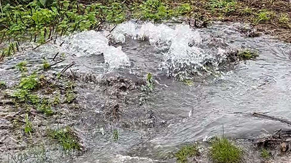 Water spewing out of manhole cover