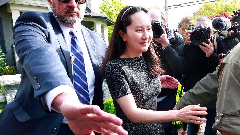 Huawei Technologies Chief Financial Officer Meng Wanzhou is escorted by security as she leaves her home on May 8, 2019 in Vancouver