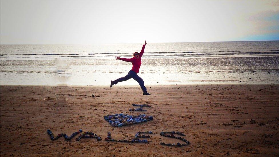 Mel Garside jumping on the beach