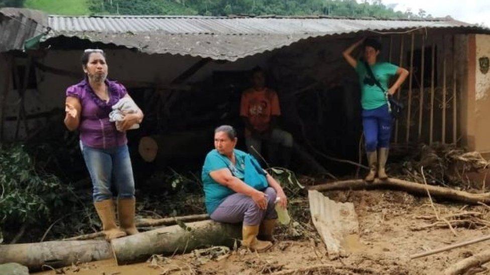 People talk on the street covered in mud following flash flooding in Tovar, Merida State, Venezuela August 25, 2021