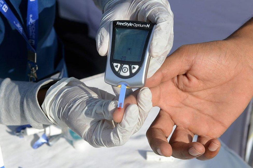 An Indian nurse (L) collects a blood sample from a policeman using a glucometer at a free diabetic health check-up camp on World Health Day in Hyderabad on April 7, 2016