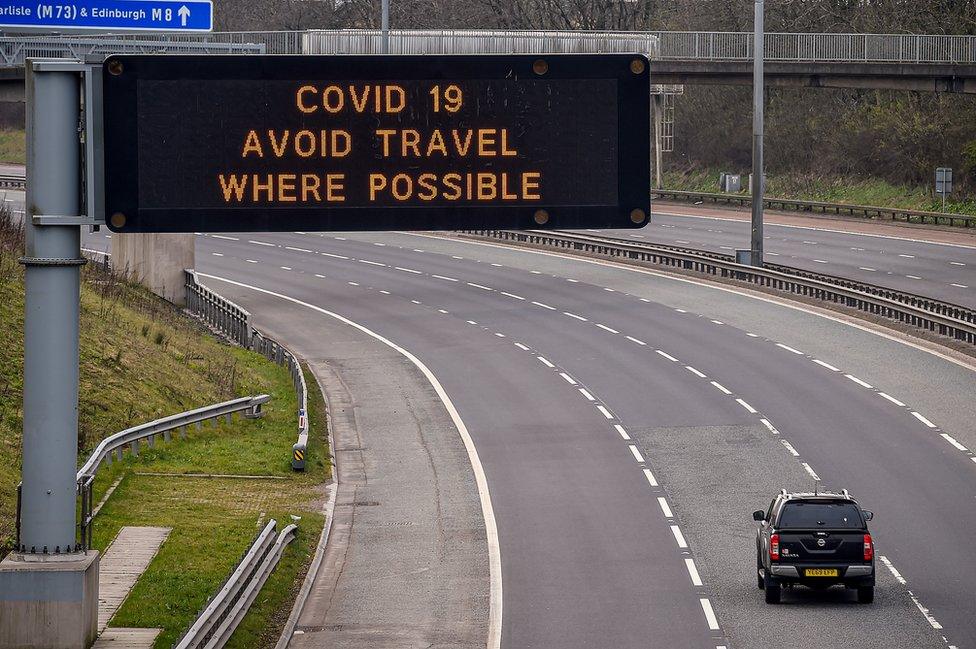 A sign on the M8 motorway advises motorists to avoid travel where possible