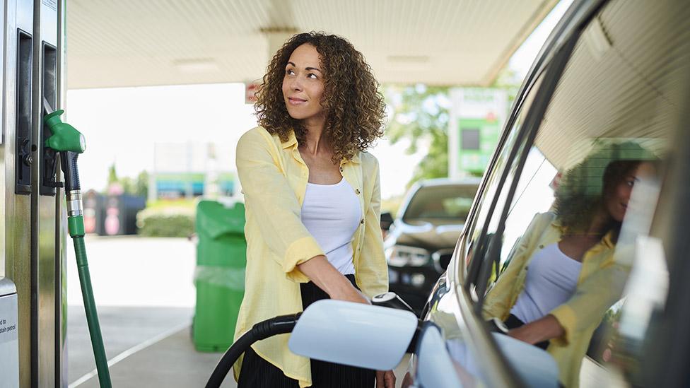 Woman filling up car at petrol pump