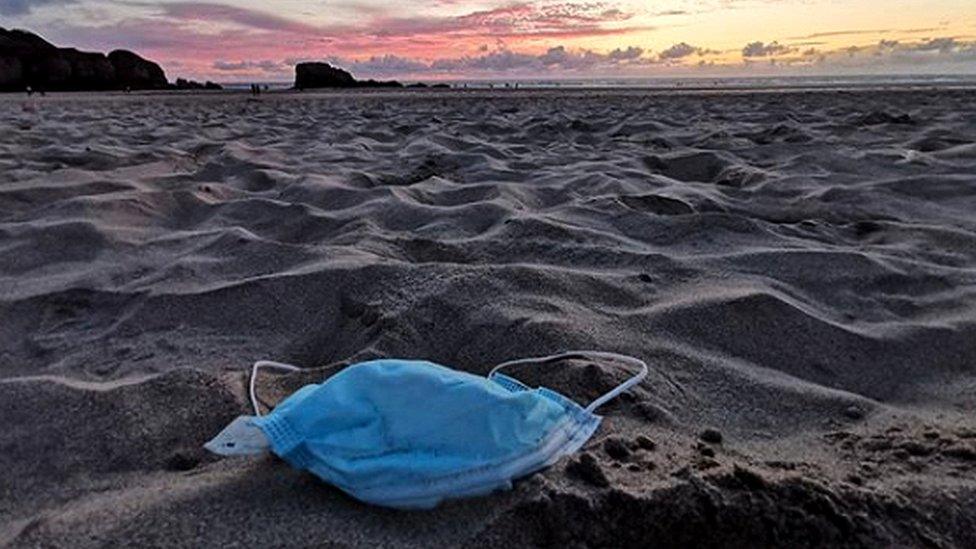 A discarded face mask on a beach