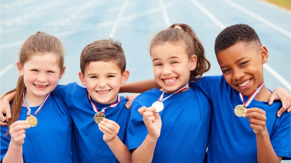 children holding medals