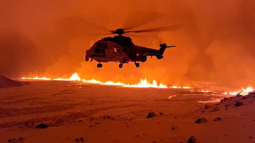 Helicopter flying over red lava