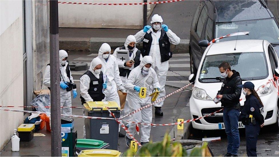 French forensic police investigators work at the site of the knife attack near the former Charlie Hebdo offices in Paris.