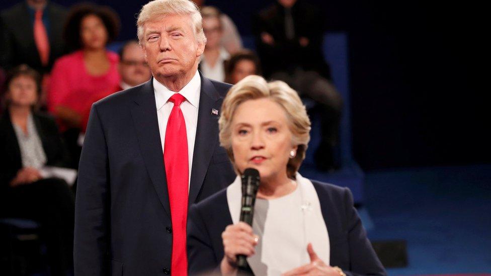 Republican U.S. presidential nominee Donald Trump listens as Democratic nominee Hillary Clinton answers a question from the audience during their presidential town hall debate