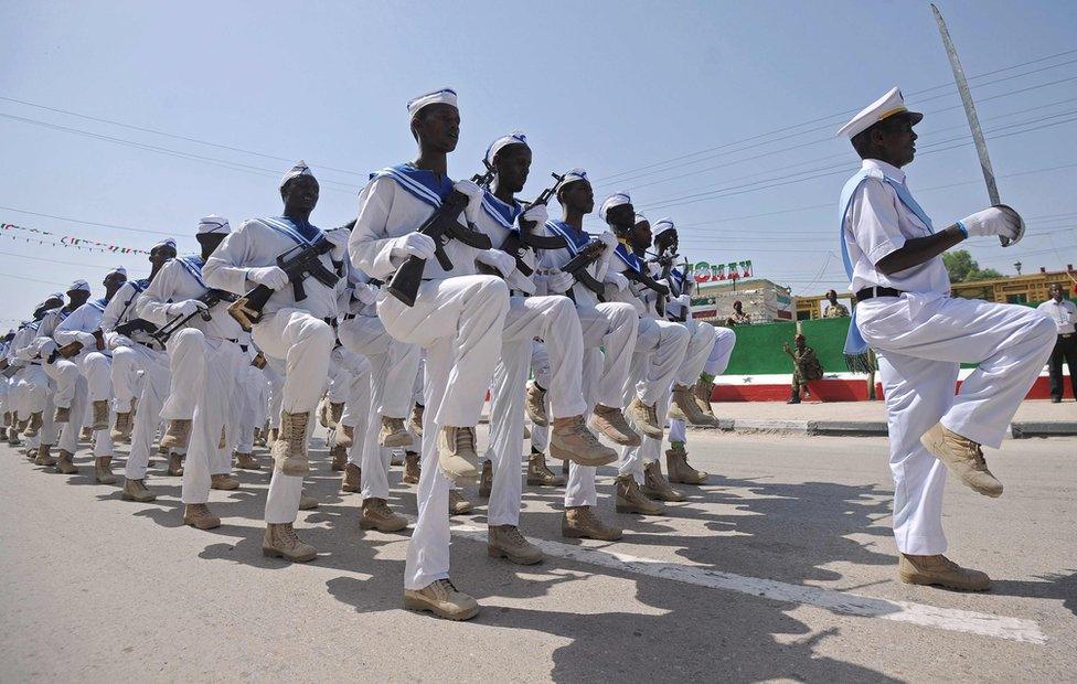People wave flags as soldiers and other military personnel of Somalia"s breakaway territory of Somaliland march past during an Independence day celebration parade in the capital, Hargeisa on May 18, 2016