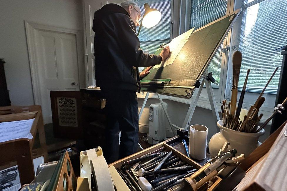 A man draws on a drawing board