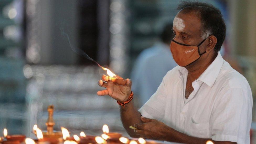 A Sri Lankan worshipper holds a candle at a Hindu temple in Colombo, Sri Lanka