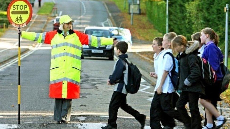 a lollipop lady with children.