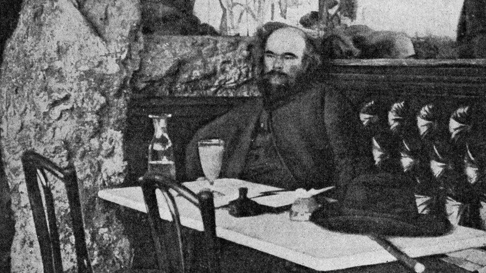 Paul Verlaine - portrait in front of a glass of absinthe at the Café Procope, Paris, France