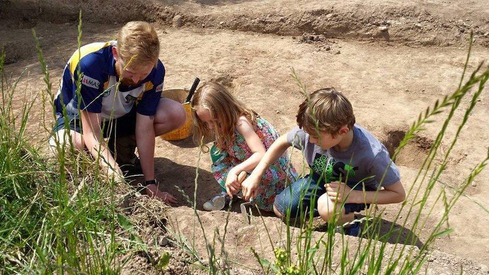 A man and children digging in the dirt