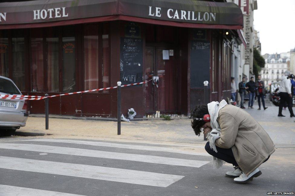 Person praying outside the Carillon restaurant in Paris