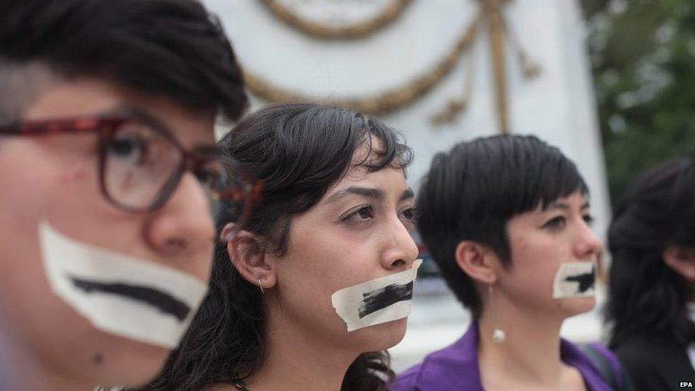 People have their mouths taped as a group of artist, students, journalist and activist stage a protest demanding justice for Ruben Espinosa in Mexico City on 8 August 2015.