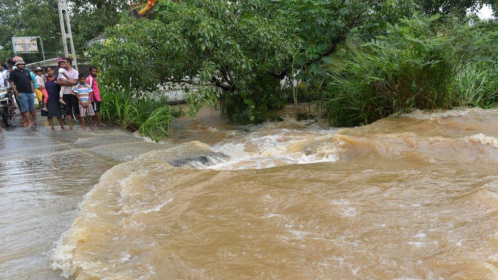 Residents make their way through floodwaters in the suburb of Kaduwela in Colombo, Sri Lanka, on May 26, 2017