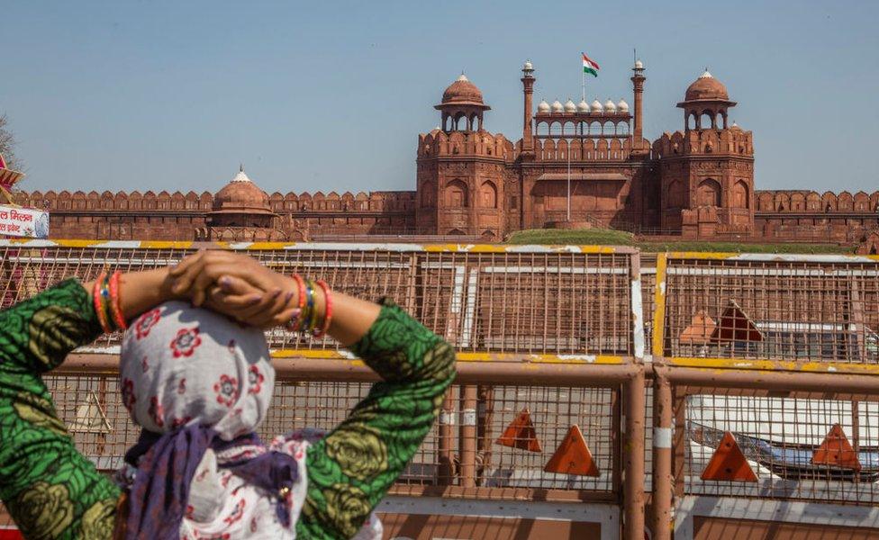 An Indian tourist disappointed to see the Red Fort, closed for tourists to prevent spread of Covid-19, as she look towards the ford on March 17, 2020 in New Delhi, India.