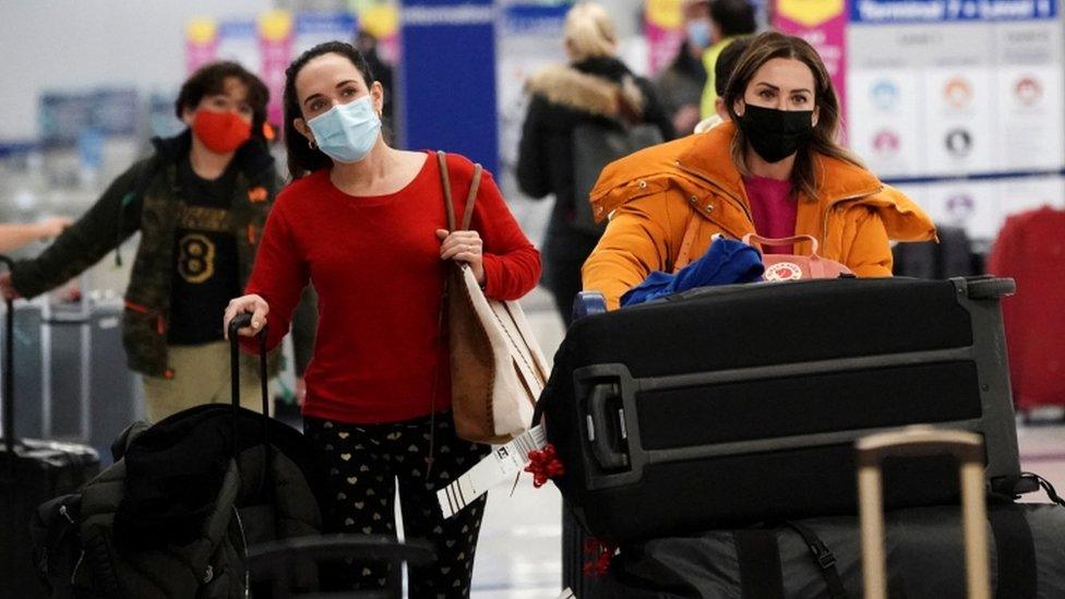 Travellers push their luggage past baggage claim inside Los Angeles International Airport