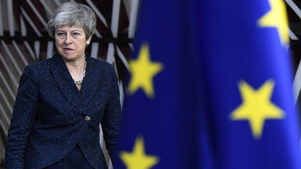 Theresa May and a Union Flag and an EU flag