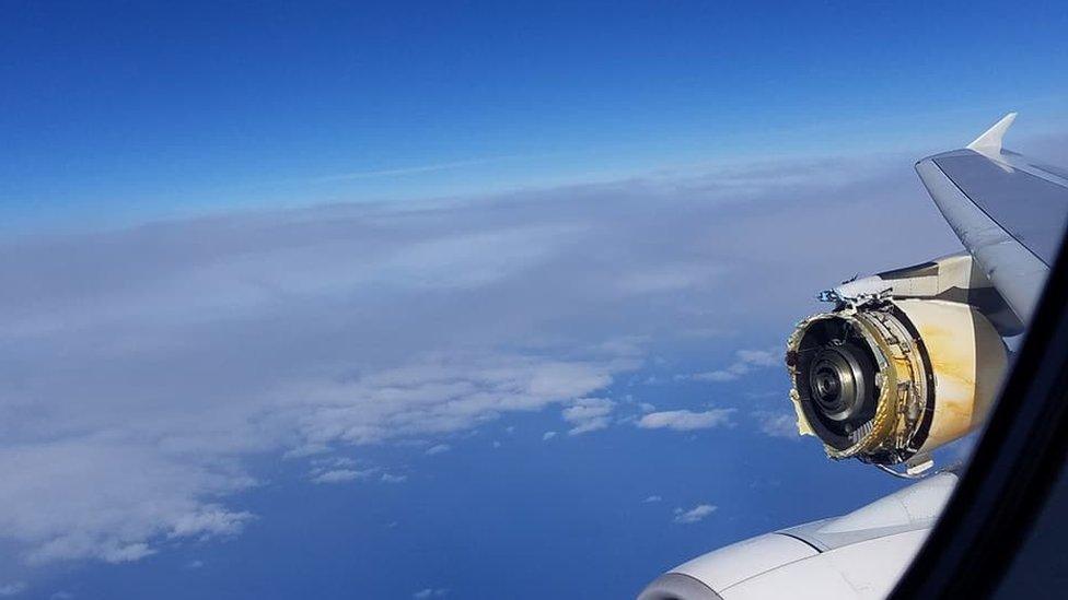 A photo shows the view form a plane in mid-air, with a severely damaged engine clearly visible, with parts missing and substantial metal damage