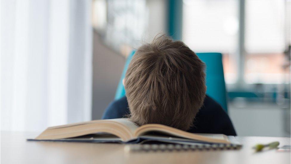 child puts head on book