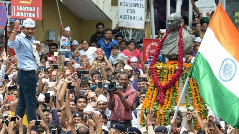 Hardik Patel raises his fist near the statue of Sardar Vallabhbhai Patel