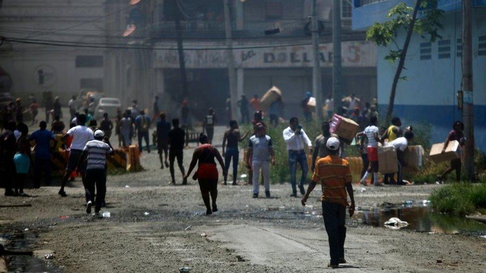 People loot stores in Colon, Panama on March 13, 2018, during a general strike.