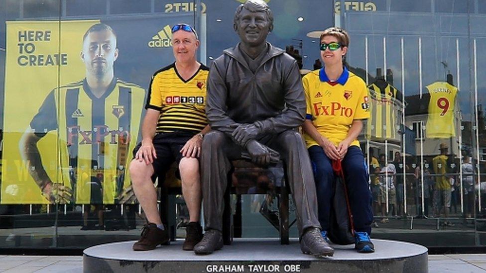 Fans pictured with statue