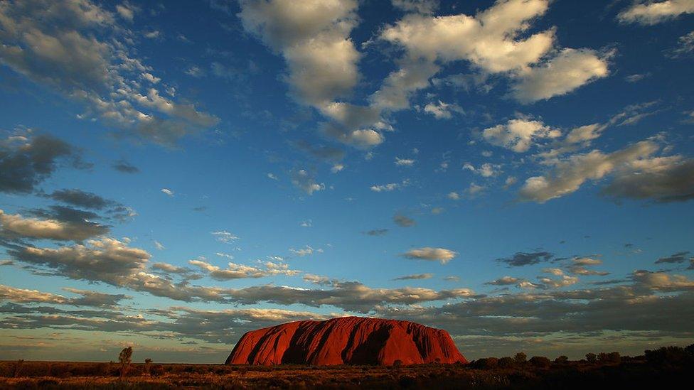 Uluru is seen as the sun sets in central Australia