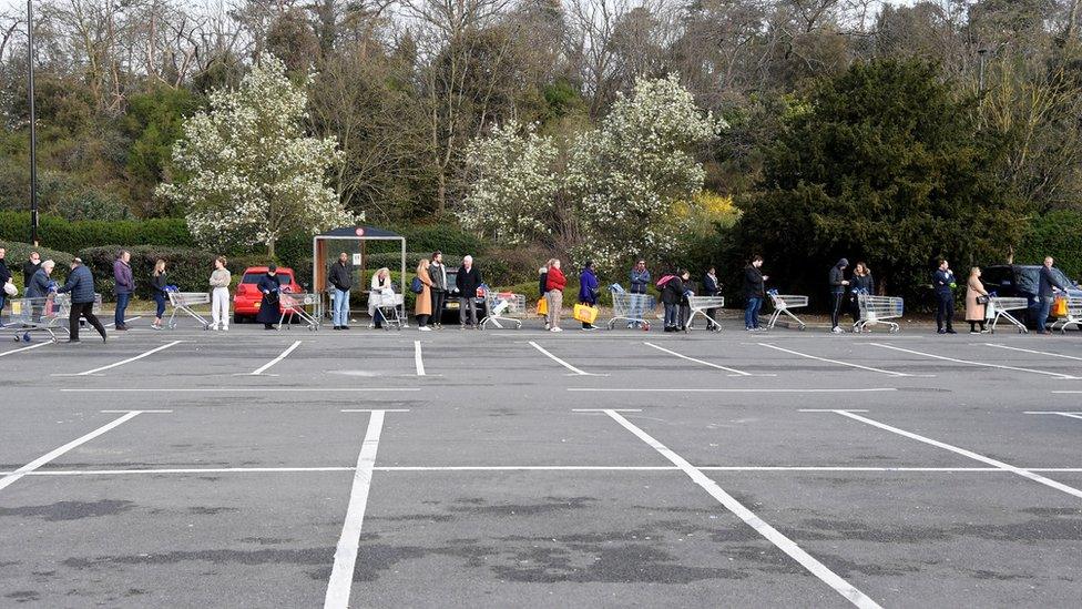 Shopper queue outside a Tesco in West London